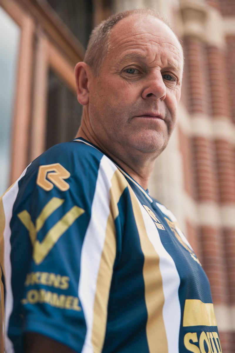De V-hals met gouden bies van het derde shirt